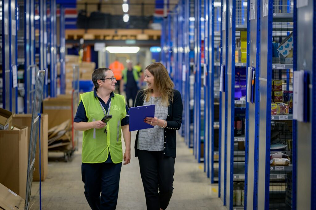 Warehouse staff walking through an aisle